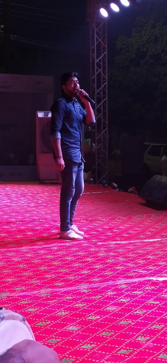 Darshan Yaduvanshi singing with a microphone on stage